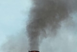 An industrial chimney emits smoke