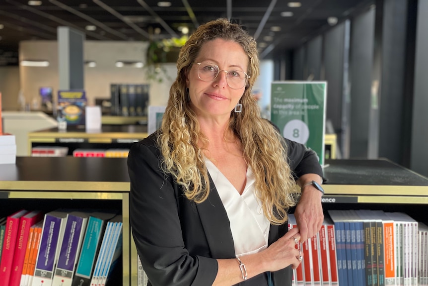 Tania Wolf in a library looking at the camera.