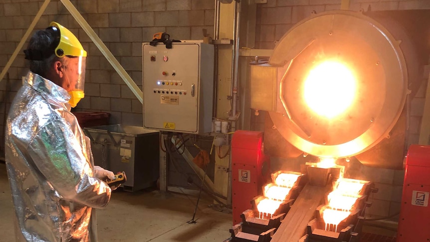 Gold bar being poured from hot furnace.