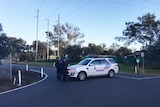 Police officers guard a street in an exclusion during a siege at Lockyer Valley property