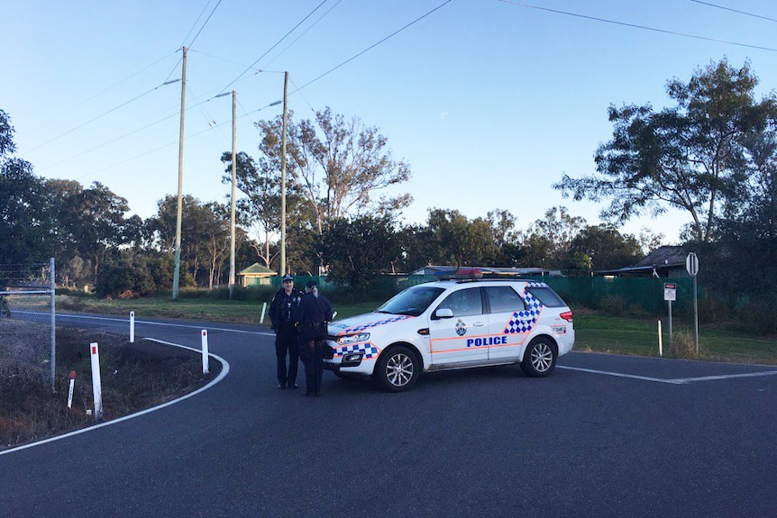 Police officers guard a street in an exclusion during a siege at Lockyer Valley property
