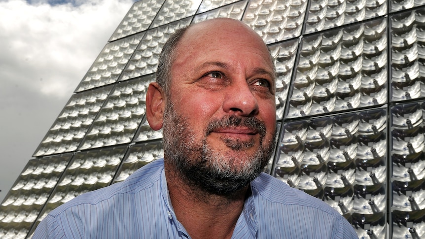 Tim Flannery in front of solar array