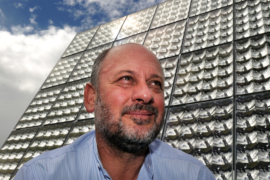 Tim Flannery in front of solar array