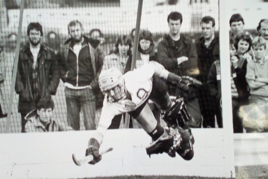 Hockey goalkeeper dives to stop a ball