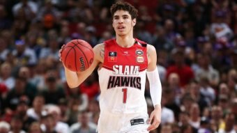 An Illawarra Hawks NBL player dribbles the ball during a game.