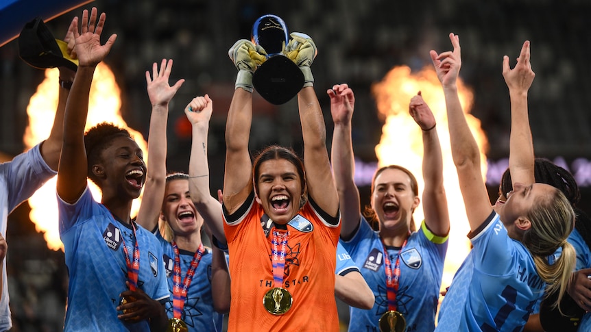 Sydney FC A-League Women players celebrate with the championship trophy.
