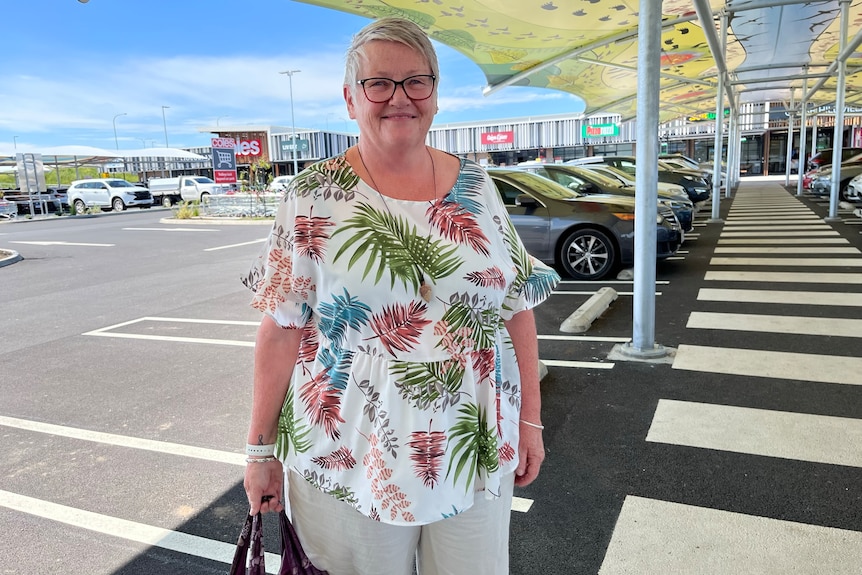 woman outside shopping centre with grocery bag