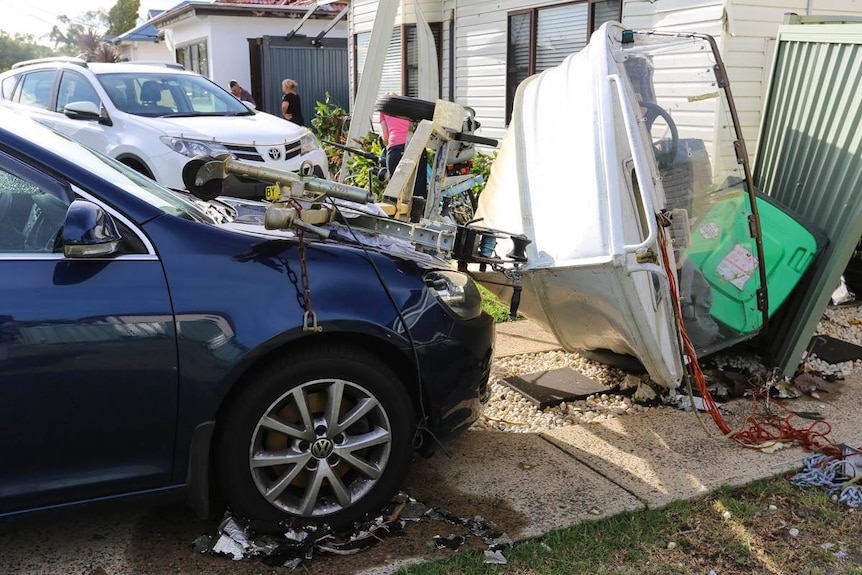 Damage from a boat thrown on top of a car