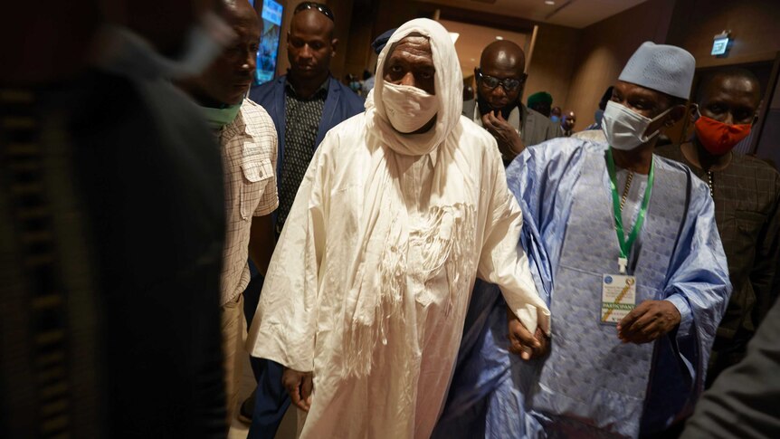 Mali's Imam, Mahmoud Dicko walks into a meeting.