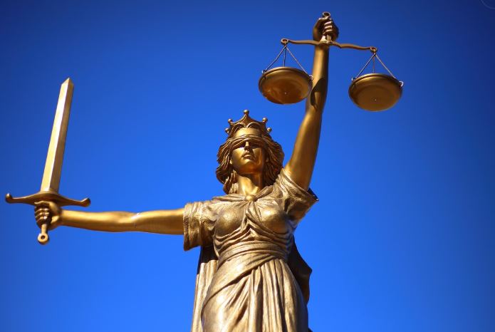 Picture of a godlen statue of a woman holding the scales of justice 