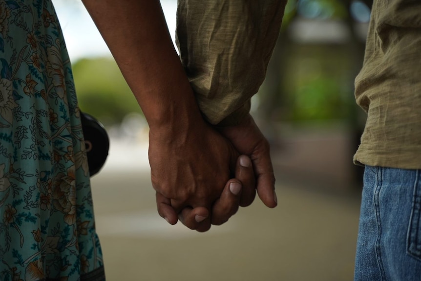 Interlocked hands of couple who have overcome heroin dependence