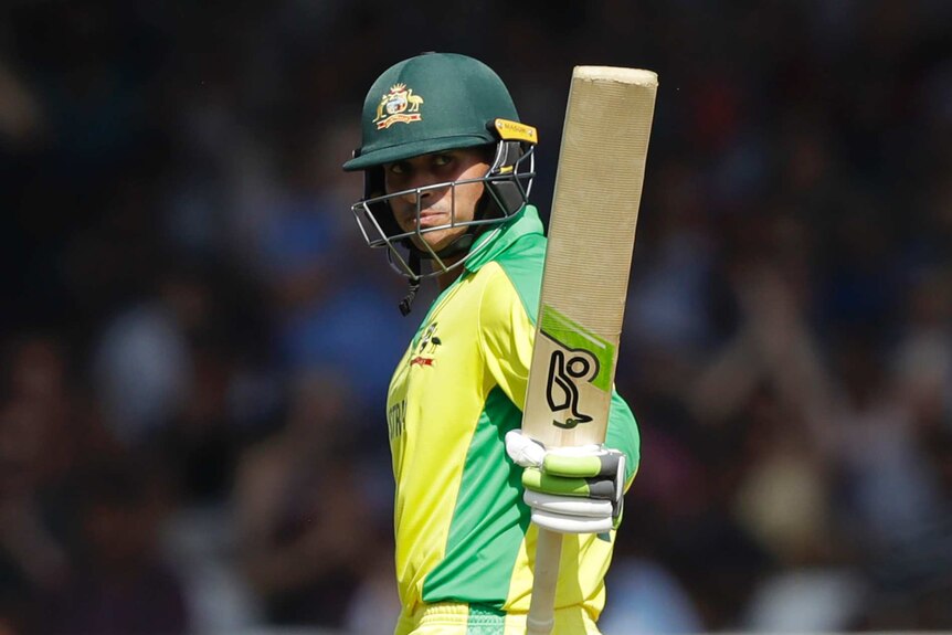 Australia batsman Usman Khawaja raises his bat after reaching 50 against New Zealand at the Cricket World Cup.