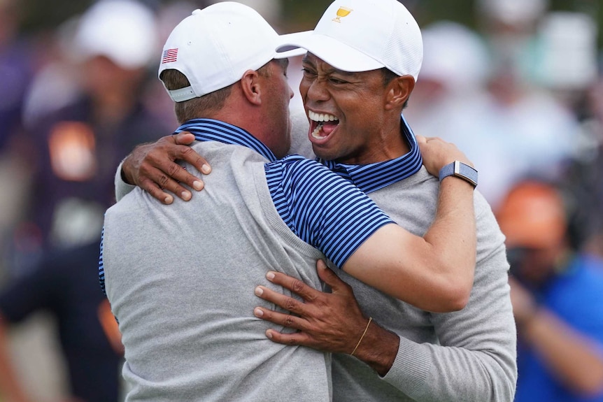 Tiger Woods screams in delight as he hugs Justin Thomas.