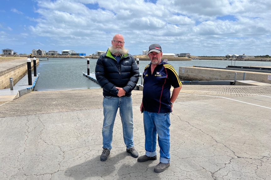 Two men standing at a large boat ramp