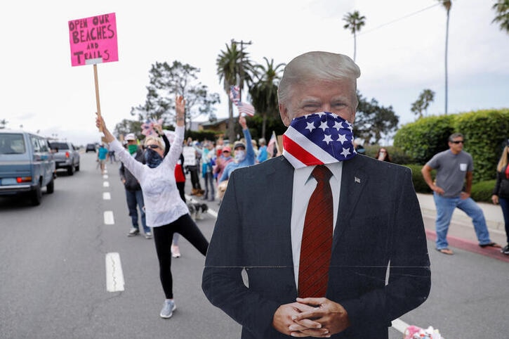 A cardboard cut out of Donald Trump with a flag over his face
