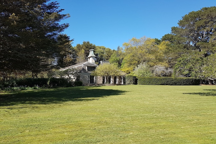 An historic house sits on a perfectly manicured parcel of rural land