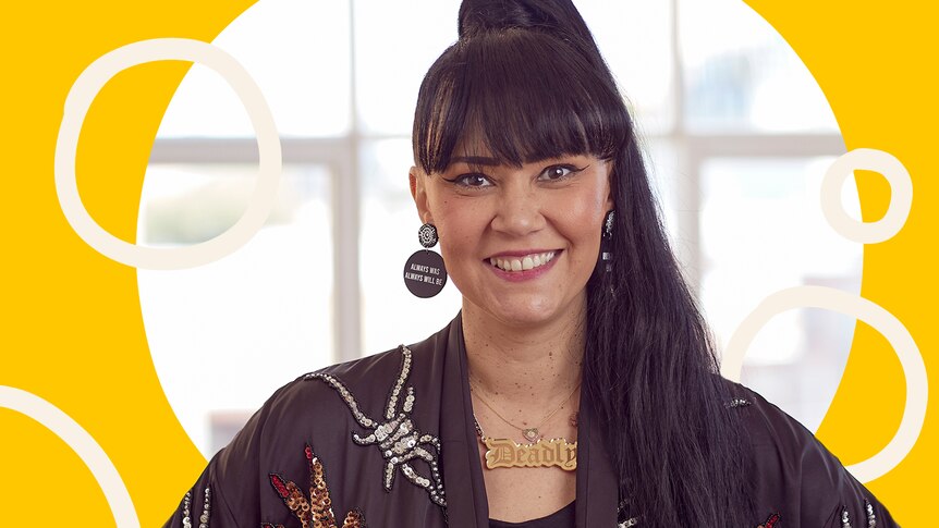 Kristy smiles at the camera, wearing jewellery she's designed, in story about how to be ally to Indigenous people