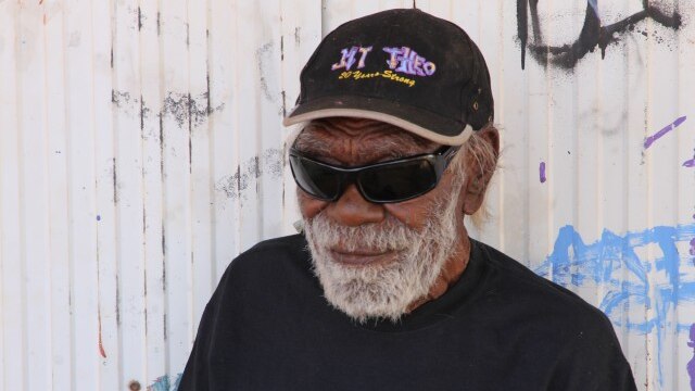 An Aboriginal man in cap and dark glasses