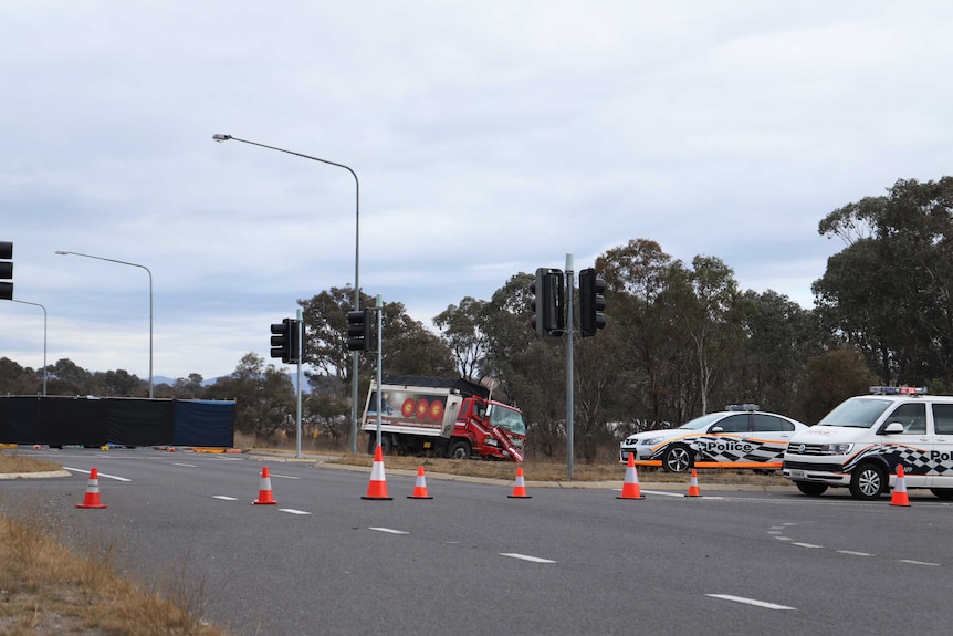 A CSG truck with its front smashed up and a black screen erected at the intersection. Two police cars are also on scene.