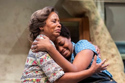 Two black women portraying mother and daughter hug