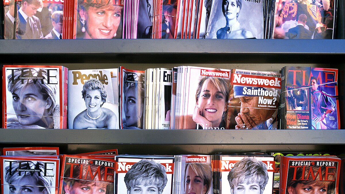 Three rows of a magazine rack lined with magazines featuring images of Princess Diana.