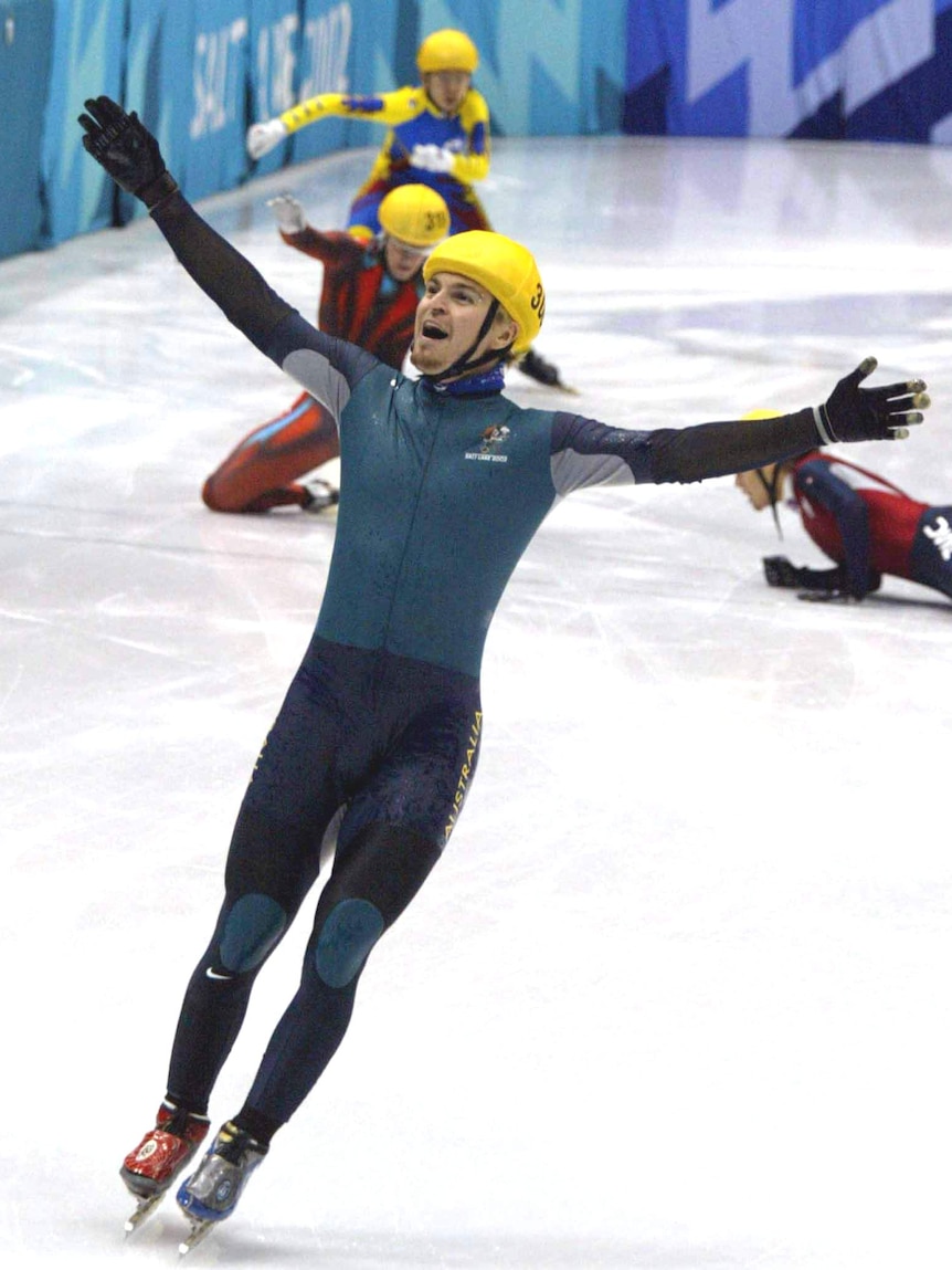 Steven Bradbury raises his arms in triumph after winning gold at the 2002 Winter Olympics