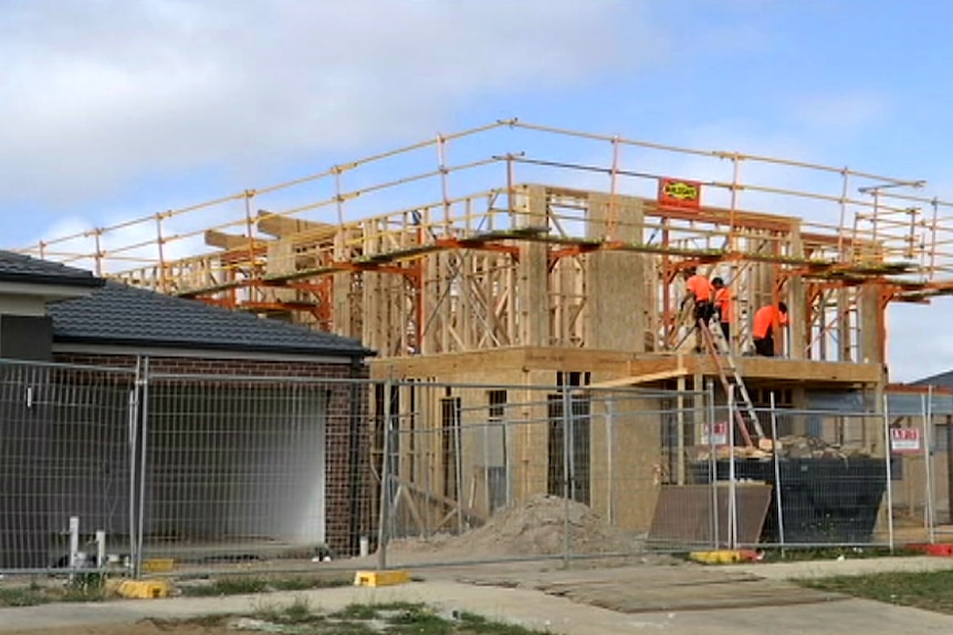 Workers build a house in a new estate near Geelong