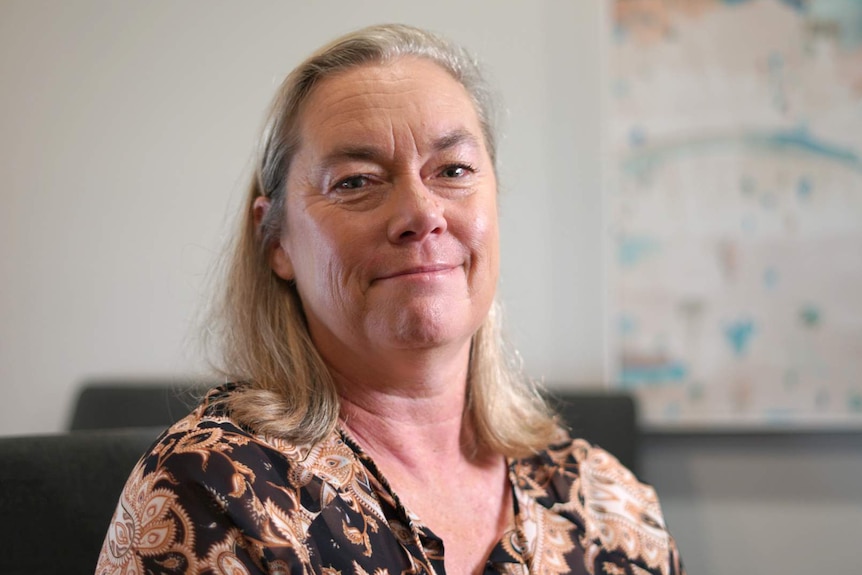 A head and shoulders shot of clinical psychologist Susan Byrne posing for a photo indoors and smiling.