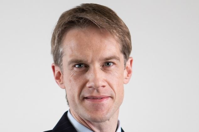 A portrait shot of a man wearing a suit.