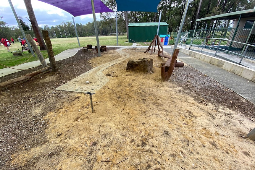 A playground with a big pile of yellow sand.