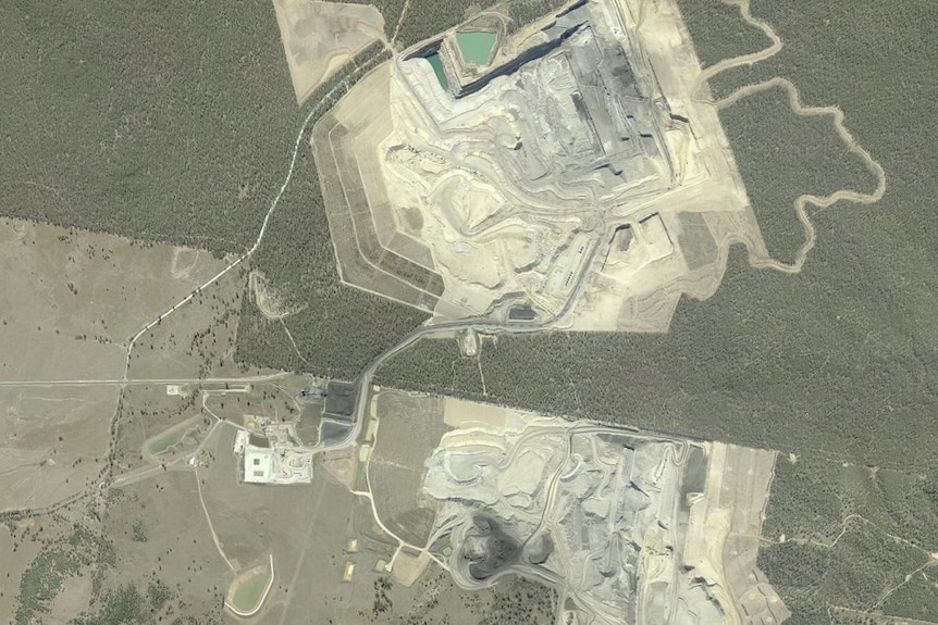 Satellite shot of the mine with water pooling in one spot, and a river nearby.