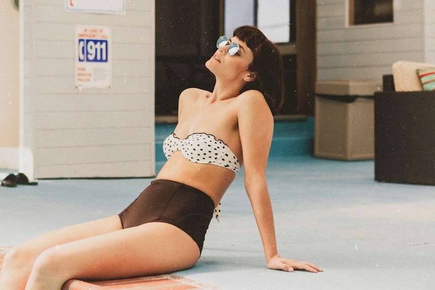 Woman wearing a high-waisted two-piece swimsuit in different prints to depict how to make swimwear shopping less stressful.