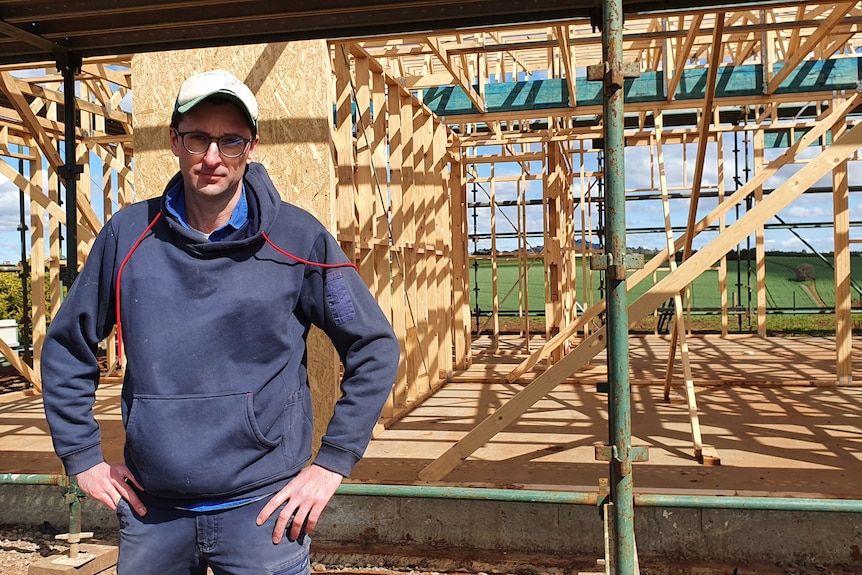A man standing in front of a house frame