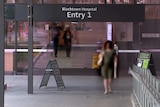 A view of the front glass sliding doors of Blacktown Hospital, people walking through