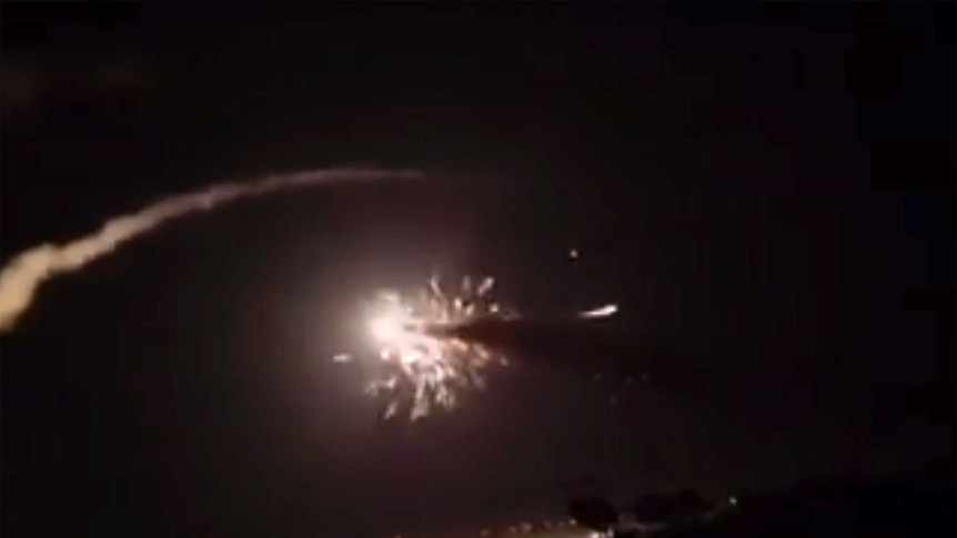 A huge explosion in the night sky as Syrian military intercepts Israeli missiles.