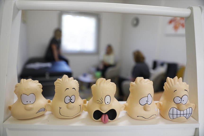 A range of emotion toys sit on a ledge in a health clinic