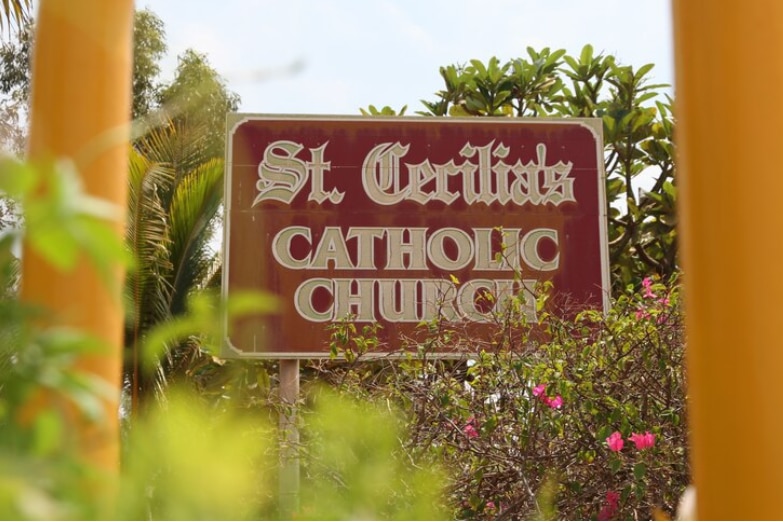 A brown sign reading St Cecilia's Catholic Church.