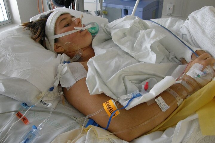 Image of a woman lying in a hospital bed. 
