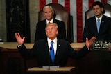 Donald Trump has his arms in the air at his State of the Union address.