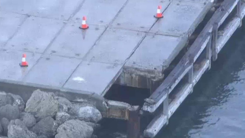 An aerial shot of a jetty showing a portion missing.