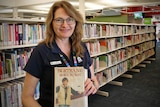 Librarian Julie Zacchei holds a well-travelled copy of Bertrand, Born to Win