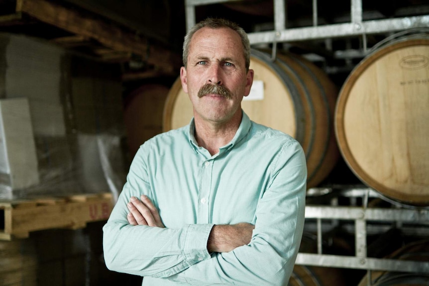 Man standing in front of wine barrels Leigh Clarnette