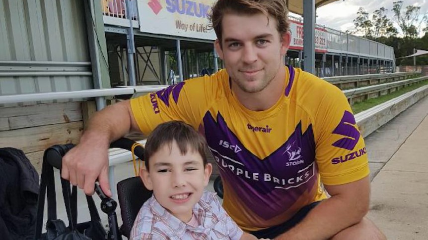 Football player and young boy in a wheelchair.