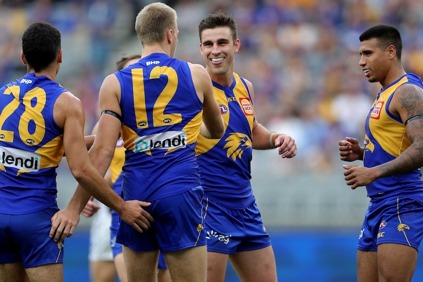 Oscar Allen is patted on the backside by Tom Cole. Elliot Yeo and Tim Kelly smile