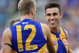 Oscar Allen is patted on the backside by Tom Cole. Elliot Yeo and Tim Kelly smile