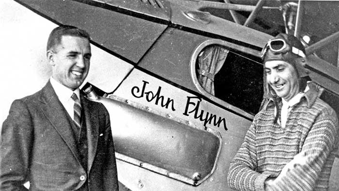 Allan Vickers (left) standing with a pilot in front of an RFDS plane.