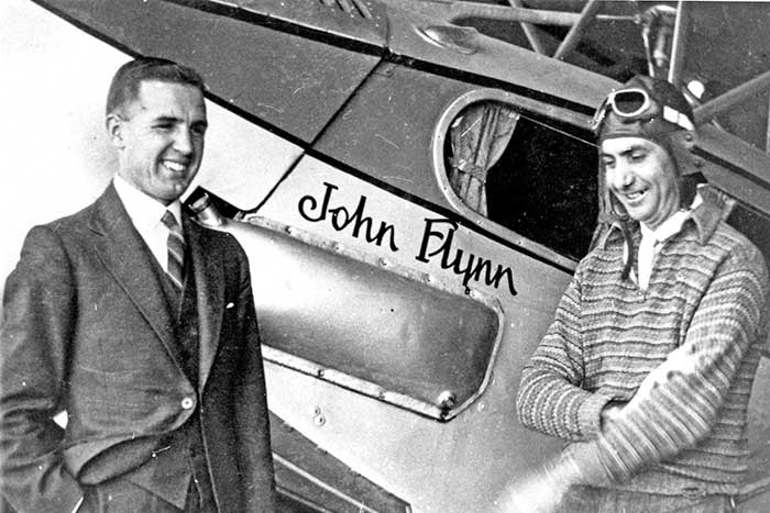 Allan Vickers (left) standing with a pilot in front of an RFDS plane.