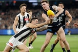 Blake Acres looks to handball while a number of Collingwood players surround him