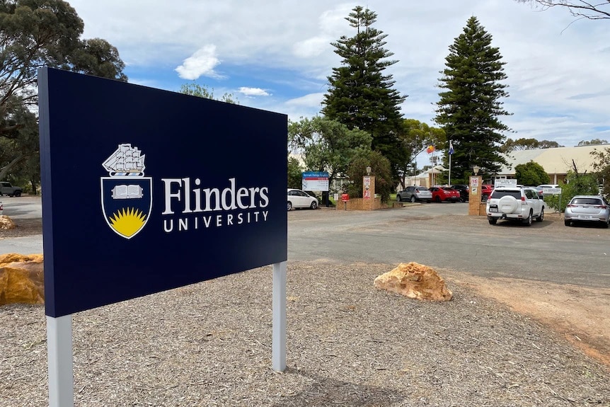 Blue Flinders University sign in a carpark 