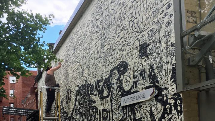 Tom O'Hern working on the mural